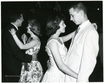 Two couples dance at the annual high school dance.