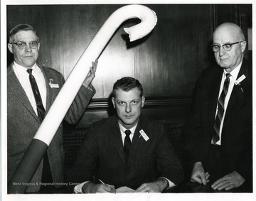An unidentified man holding a huge white cane, Mayor Charles Blissett sitting, and Z.A. Clark pose for a group portrait on White Cane Day.