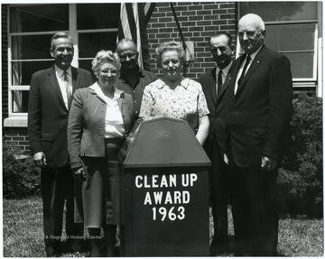 Group standing behind a trash bin.  The men are from left to right: Bob Creel, Earl Reiner, unknown, Z. A. Clark.