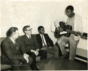 African-American boy plays guitar for three others. 'Julian Martin is second from left. 