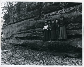 Couples pose for a photograph on a ledge. Possibly at Coopers Rock.