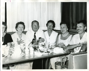 'Left to right: Mrs. Parke Johnson, Mrs. Fred Glisan, President, J.W. Ruby, Mrs. Ruby, Mrs. Russ Thomas, and Dr. Parke Johnson, Masontown physician.'