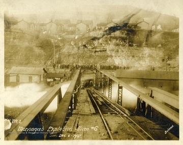 Crowds gather above and at the end of the trestle leading into mine no. 6 after the explosion.  Note: image is taken from the original print donated to the West Virginia Collection.