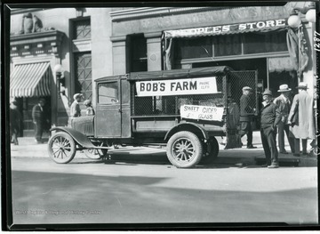 Bob's Farm Truck is parked in front of the Brown Building on High Street in Morgantown, West Virginia. Sign advertises Sweet Cider 5 cents a glass.