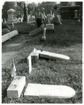 Unidentified man inspects damage in the Oak Grove Cemetery after it was vandalized. 