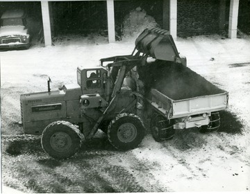 A man is loading a cinder truck in Morgantown, West Virginia.