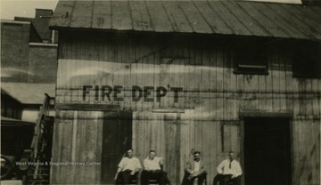 Four men sitting in front of the Morgantown fire department.