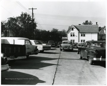 View of cars in the parking lot on the corner of Spruce and Pleasant St. Morgantown, W. Va. with Hastings Funeral home, formerly Hardigans Hospital.