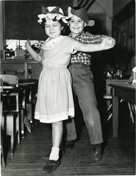 View of two children dancing in a classroom.