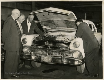 View of the Auto Mechanic's Shop at Morgantown High School, with Z. A. Clark, Assistant Superintendent of schools and Mr. Clise, Auto Mechanic teacher and others around a car.