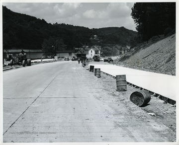 'Looking toward Morgantown on US 119 improvement. A relocation project for US 119 south of Morgantown is scheduled for completion this summer. Pictured is a northward look at paving work being done by Harman Brothers of Grafton, which was awarded the US 119 contract April 6, 1964, on a qualified low bid of $1, 596,255. Besides construction of 0.86-mile of US 119, the project includes a new Cobun Creek bridge.'