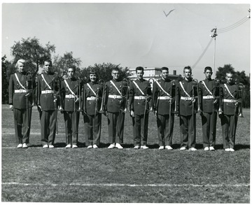 View of the members of the Morgantown High School band trombone section pose on the football field in Morgantown, W. Va. Left to Right: Arne Linquist, Steve Stevenson, unknown, Peggy Newcomb, unknown, Bob Bowers, unknown, George Bennett, unknown, and Jay Bucklew.