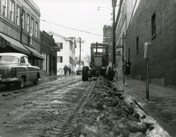 Three gentlemen are walking past Western Union while a lady is walking down from the Police Department on the other side of Fayette Street in Morgantown, West Virginia. 