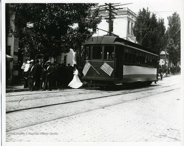 Passengers are departing a streetcar on High Street in Morgantown, West Virginia.