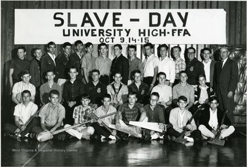 Group portrait of students on the FFA 'Slave - Day' at University High School October 9, 14-15, year unknown.  Students in the front row holding saws, wrenches, shovels, and axes.