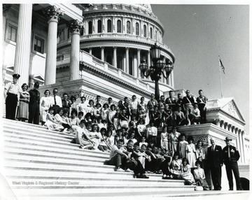 Group portrait of members of the Morgantown School Safety Patrol with Deputy Fred Elig and Congressman Harley O. Staggers on the steps of the capitol building.