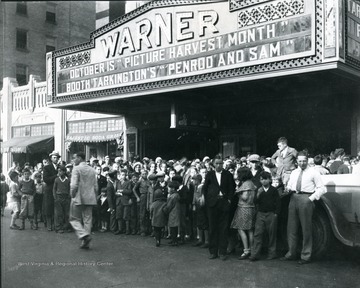 A group of children in front of the Warner Theatre on High Street.  Marquee reads, 'October is 'Picture Harvest Month' and 'Booth Talkington's 'Penrod and Sam.'