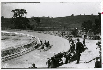 People are watching horse racing at the Morgantown Fair which was held on the new Evansdale track in 1909. 