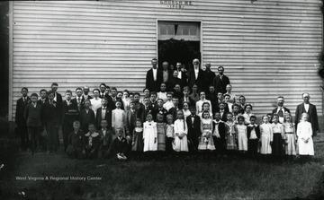 A photo of a large group of people in front of the M. E. Church.