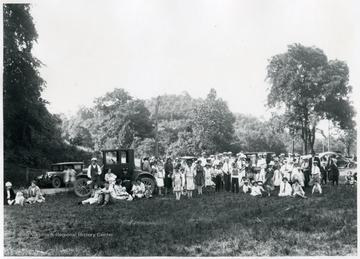 View of a large group of people and a small band gathered in a park setting for a  labor or political meeting in Morgantown, W. Va.
