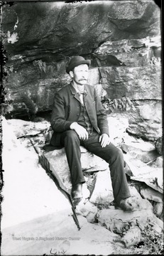 An unidentified man sitting on rocks.