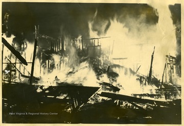 Harsh building up in flames. 'Harsh building in flames after collapse of roof and two walls--shows sections of roof in left foreground.'