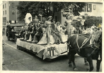 Horse pulling a float filled with people in a Barbour County parade.