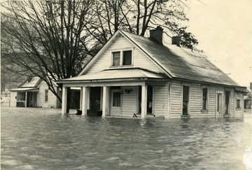 Water is covering porches and reaches up to the first floor windows.