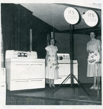 Women standing by stoves at the appliance display.