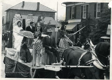 Horse is pulling a parade float filled with people in Barbour County, West Virginia.