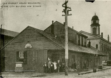 Several people stand in front of the Old Market House where the city building now stands in Wellsburg, W. Va.