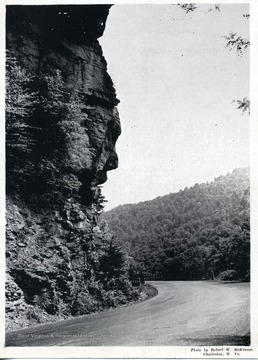 'Fayette County's unusual Great Natural Wonder: Old Rock Head. On Route 21 at Honey Creek Bridge at Chimney Corner near intersection with Route 60--the Midland Trail. Great Stone Face gazes over turbulent New River where stream plunges down rocky canyon. Natural rock face said to surpass Great Stone Face in White Mountains of New Hamshpire. Face best seen as one stands on Chimney Corner approach to high bridge over Honey Creek on way to Fayetteville.'