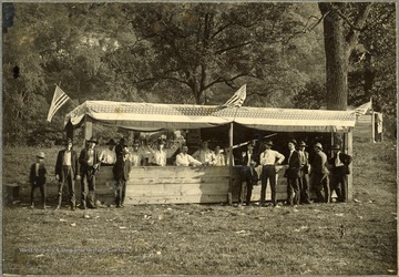 View of a group of men beside a concession stand at the Fourth of July Celebration in the Petersburg Gap in Grant County, W. Va.