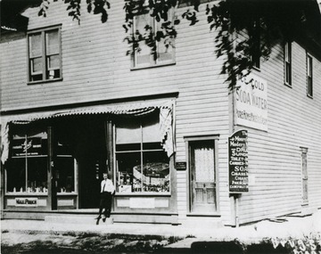 View of Hackney's Drug Store at the Northeast corner of Main and Washington Streets occupied this location from 1910 to 1950. This building was built in 1910 by Dr. R. E. L. Hackney of Washington, D. C. who was a Dentist, and made his home in Moorefield from 1910 until his death. He operated a Drug Store and Soda Fountain on the first floor and had his Dental Offices on the second floor front rooms. The back rooms on the second floor were occupied for some years by Club Do-Easy. Dr. Hackney sold out in (date unkown) and Chambers and Williams operated a garage here, building a shop farther back on the lot, which is now the Moose Home. The Loyal Order of Moose bought the property in (date unknown) having rented it for several years from another owner. In (date unknown) they tore down the Drug Store Building. A Bakery was operated in this building at one time by a man by the name or Ours.