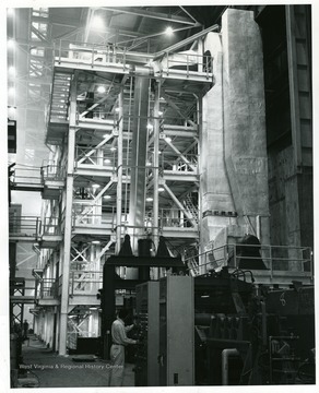 Huge tower near the entry end of new Number 3 continuous galvanizing line in the  Sheet Mill Department at Weirton Steel Corporation division of National Steel Corporation is a five-stack annealing unit having the capacity to handle heavy gauges. The strip steel is seen in the photo moving up at the center of the annealing unit, and following annealing it enters the galvanzing pot to be coated with zinc. In the right foreground is part of the cleaning unit of the line which operates at 300 feet per minute and can produce 12,000 toms per month. 'Weirton Steel Corporation Photograph Department.'