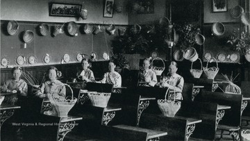 Scene of girls weaving baskets in the school building at the West Virginia Industrial Home for Girls in Harrison County.