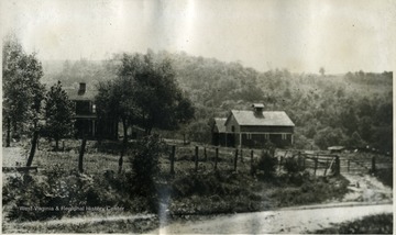 'This is a tennant house with barns on the left used for housing machinery and hogs. The trees faintly seen in the background are in large part Point Breeze woods across Buffalo creek. The road is the one to Wheeling. The picture is taken from the cow barn.'