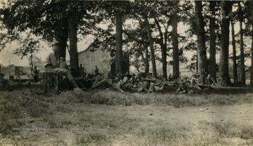 Group of students at the Greenbrier Military School sit in the shade with their rifles.