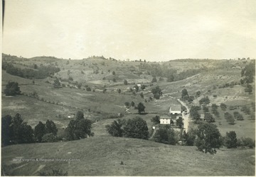 'A view of Jesse Run showing the farms of Mr. W. H. Melhorn and Mrs. Hartley. These farmers each market a case of eggs during the spring months. The greatest interest in poultry is shown by the farmers living in the 'runs' and 'forks.' From photo album labeled 'Stewart A. Cody, County Agent, Jackson County, 1912.'