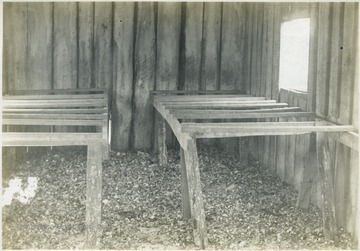 'Interior of Mr. C. E. Crow's poultry house. The perches are well arranged, the ventilation is fair, the house is well constructed, but the value of the poultry manure as a fertilizer is not considered. This is a general condition in certain parts of the county.' From photo album labeled 'Stewart A. Cody, County Agent, Jackson County, 1912.'