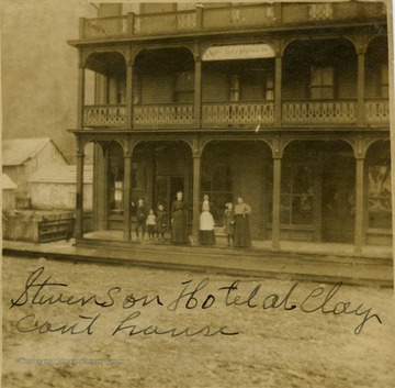 A group of people stand on the porch of the Hotel Stephenson. 'Stephenson Hotel at Clay Courthouse'.