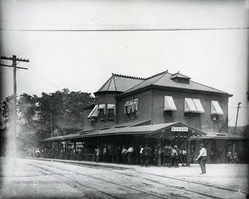 A train approaches the Weston Train and Trolley Station as men crowd around.
