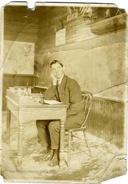 Clifford Coombs sitting at his desk teaching at Union School, near Lowesville, West Virginia. Lowesville is now present day Rivesville, West Virginia.