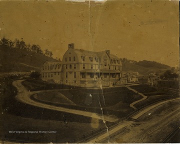 'Picture of the Bluefield Inn, taken in 1890. Princeton Avenue, in the foreground, was unpaved. The building is now used as the Division Office of the Norfolk and Western Railway. There is a boardwalk in front of the building with wooden steps leading to the building.'