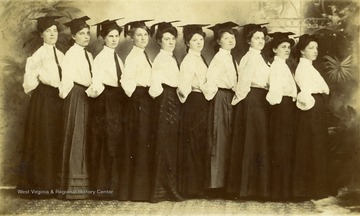 A group portrait of ten women graduating from the Alderson Baptist Academy in Pickaway. 'Mamie Beckett in front, daughter of Daniel Beckett, confederate soldier, and Eliza Peck Beckett. Great granddaughter on mother's side fo Henry Mann, son of an original white settler in Hunter's Springs, near Greenville, in Monroe County.'