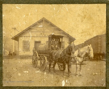 Two horses are standing in front of a Standard Oil Delivery Wagon in Eckman, McDowell County, West Virginia.