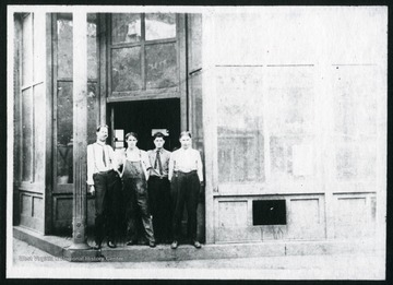 A view of W.W. Logan's Print Shop in McDowell County, West Virignia. Standing in front of the shop are: W.W. Logan, W.W. Johnson, Strother Tabor, and Mr. York. W.W. Logan's Print Shop is currently where Friendly Grill is located.