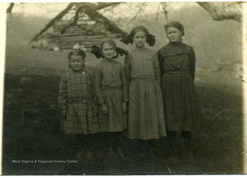 Photograph of Leah Reed, Helen Ballard, Maggie Ballard, and Mary Reed 'in order from left to right' on a postcard.