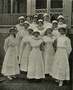 View of a group of uniformed nurses posed in front of King's Daughter's Hospital in Martinsburg, W. Va.