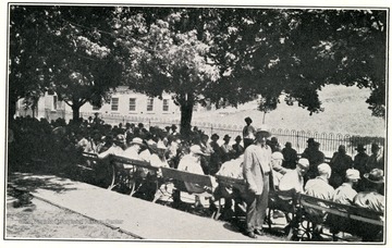 Patients sitting on benches at Spencer State Hospital.